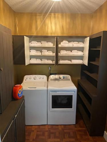 a small kitchen with two washers and a stove at Evergreen Estates 3-Bedroom Private in Fayetteville