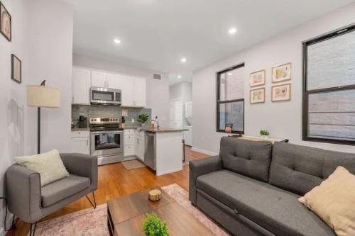 a living room with a couch and chairs and a kitchen at Prime OTR off Vine St, Lux Full Bed, Fast WiFi, Fully Equipped, 50in TV, Sleeps 4ppl in Cincinnati