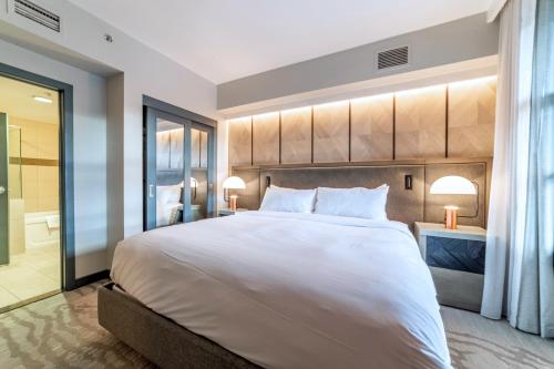 a bedroom with a large white bed and a bathroom at Luxury 2 Bedroom Penthouse with Stunning Views! in Mammoth Lakes
