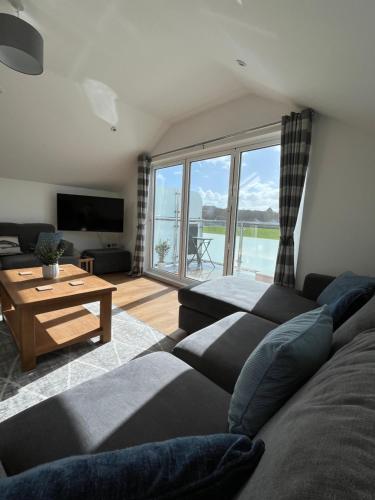 a living room with a couch and a large window at The Boathouse in Mylor Bridge