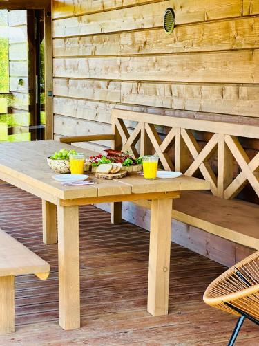 a wooden picnic table with food on a deck at Chatka nad Jeziorem Czostków JustChill in Czostków