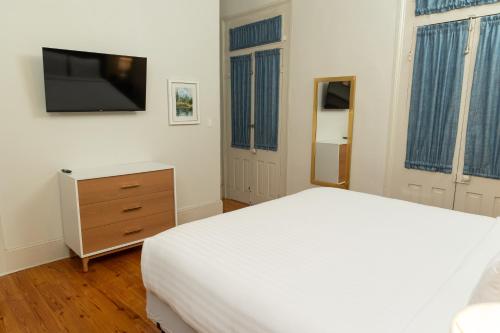 a bedroom with a bed and a dresser and a tv at Inn on Ursulines, a French Quarter Guest Houses Property in New Orleans