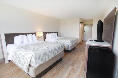 a hotel room with two beds and a flat screen tv at Americas Best Value Inn Winston-Salem in Winston-Salem