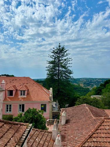 a house with red tile roofs and a tree at CASA da VILLA STUDIO in Sintra