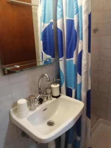 a bathroom with a sink and a shower curtain at Aronis Apartments in Benitses