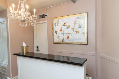 a painting of birds on a wall with a chandelier at Inn on St. Ann, a French Quarter Guest Houses Property in New Orleans