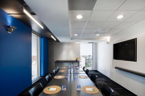 a conference room with a long table and chairs at Alt Hotel Winnipeg in Winnipeg