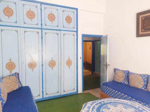 a bedroom with blue and white walls and a blue couch at Casa Plasa Grande in Chefchaouene
