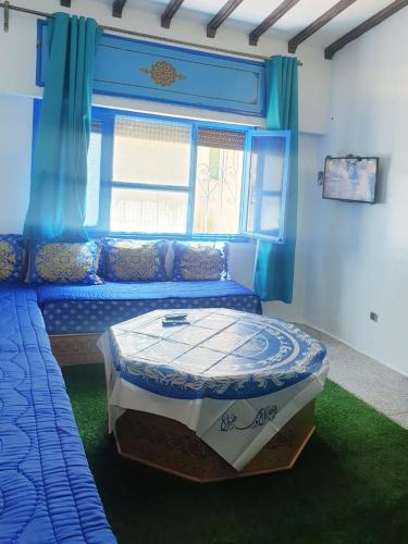 a bedroom with a bed in a room with a window at Casa Plasa Grande in Chefchaouene