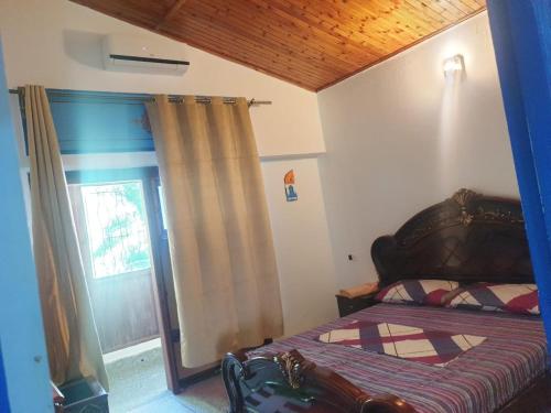 a bedroom with a bed and a window with a curtain at Casa Plasa Grande in Chefchaouene
