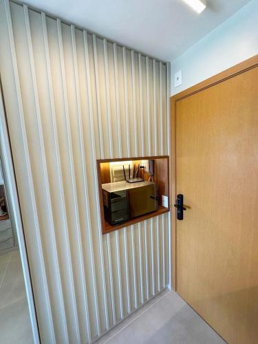 a room with a wall with a door and a microwave at New Studios by VLV Stays in Salvador