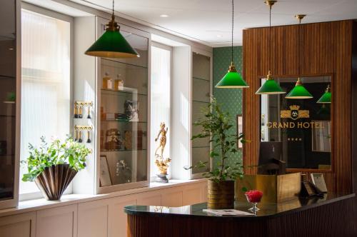 a shop with green pendant lights and a counter at Grand Hotel Marstrand in Marstrand
