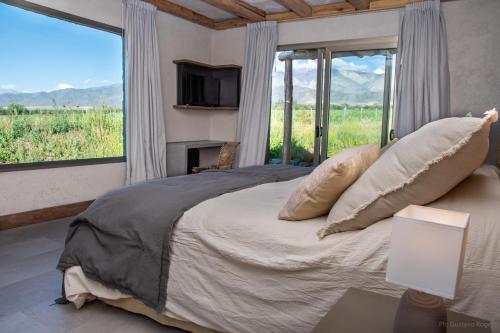 une chambre avec un grand lit avec une grande fenêtre dans l'établissement Villa Atamisque V, à Tupungato