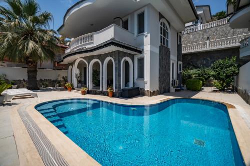 a swimming pool in front of a house at Villa mit einzigartigem Ausblick in Alanya