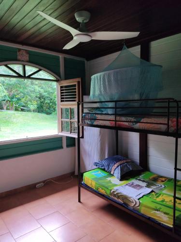 a bedroom with two bunk beds and a window at La Villa Mil'Or, Idéale pour vos petits évènements & Magnifique vue sur la Baie du Robert in Le Robert