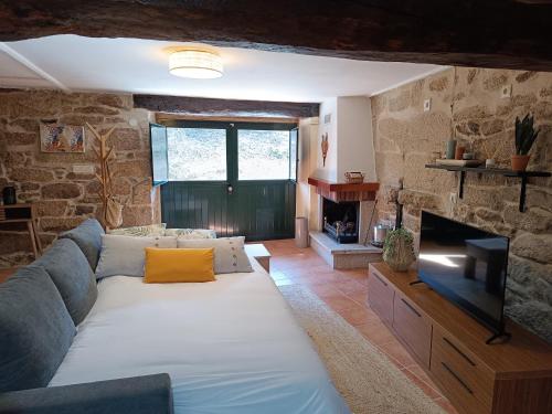 a living room with a couch and a flat screen tv at Luz do Sil in Ourense