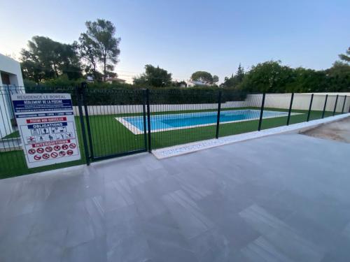 une clôture métallique avec piscine en arrière-plan dans l'établissement T2 à 50 mètres de la mer, belle vue sur végétation, à Saint-Raphaël