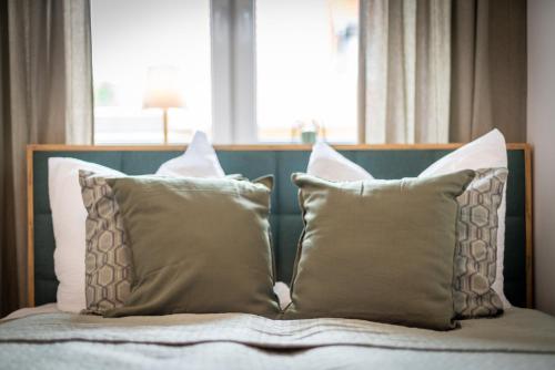 a bed with four pillows on it in front of a window at EasyForest Bad Driburg 10P Switch TV 2xApartments in Bad Driburg