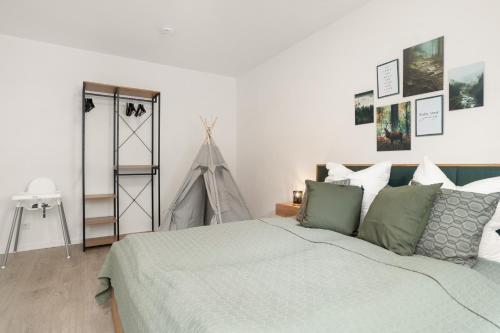 a bedroom with a large bed with green pillows at EasyForest Bad Driburg 10P Switch TV 2xApartments in Bad Driburg
