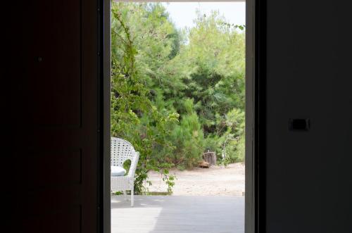 a door leading into a room with a chair outside at Tancredi's Seaside Home in Granelli