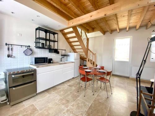 une cuisine avec une table et des chaises dans une pièce dans l'établissement Le Bel Air -jardin - proche Mer & parking gratuit, à Mers-les-Bains