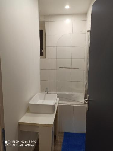une salle de bain blanche avec un lavabo et un miroir dans l'établissement TRES BEL APPARTEMENT AUX PIEDS DE LA GARe, à Épinay-sur-Seine