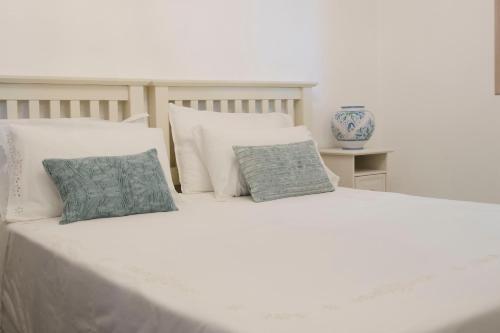 a large white bed with two pillows on it at Tancredi's Seaside Home in Granelli