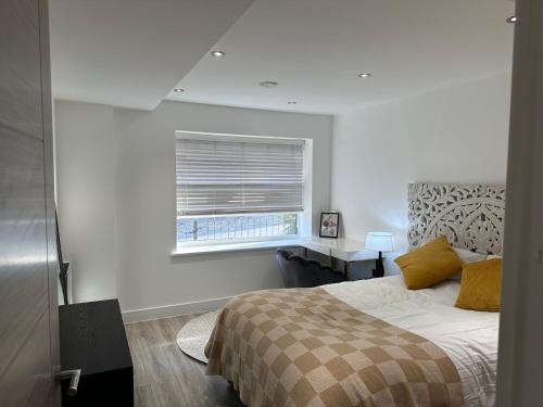 a white bedroom with a bed and a window at Luton Airport Area Apartment in Luton