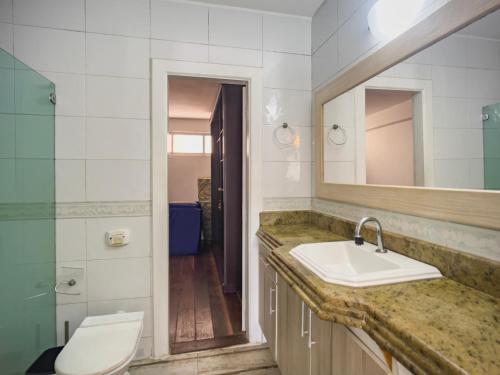 une salle de bain avec un lavabo et des toilettes dans l'établissement Cabo Frio 3 Suítes, Piscina, 4 Vagas, Praia 8min, à Cabo Frio