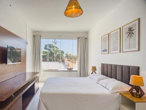 une chambre avec un lit et une grande fenêtre dans l'établissement Cabo Frio 3 Suítes, Piscina, 4 Vagas, Praia 8min, à Cabo Frio