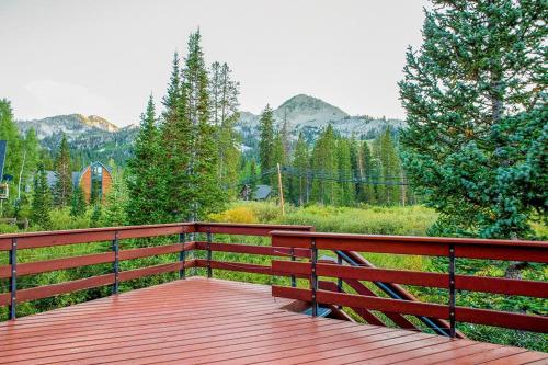 a wooden deck with a view of the mountains at Moose Manse in Brighton