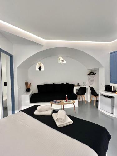 a bedroom with a black and white bed and a table at Oinos Luxury Suites in Foinikiá