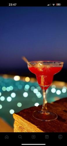 a red drink in a martini glass on a table at Blue Sky in Ios Chora
