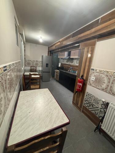 Cette chambre comprend une table et une cuisine équipée d'un réfrigérateur. dans l'établissement Chambre d hôtes Arcis sur Aube, à Arcis-sur-Aube