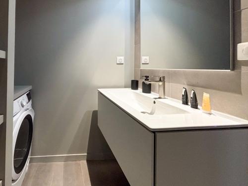une salle de bain avec un lavabo et une machine à laver dans l'établissement Bihit T2, trebeurden, à Trébeurden