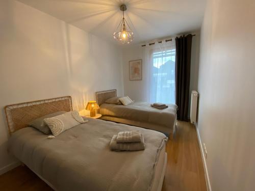 une chambre avec deux lits et une lampe et une fenêtre dans l'établissement Appartement Hakuna Matata 5 min Disney Parking, à Montévrain
