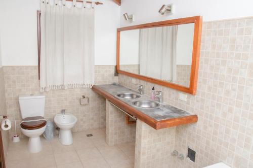 a bathroom with a toilet and a sink and a mirror at Casa La Selva in Sierra de los Padres