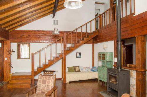 a living room with a staircase and a fireplace at Casa La Selva in Sierra de los Padres