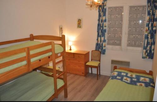 une chambre avec deux lits superposés et un bureau dans l'établissement Maison oleronaise, à Saint-Georges-dʼOléron