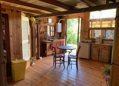 Il comprend une cuisine avec une table et des chaises. dans l'établissement Studio chalet Sud Ouest, à Soustons