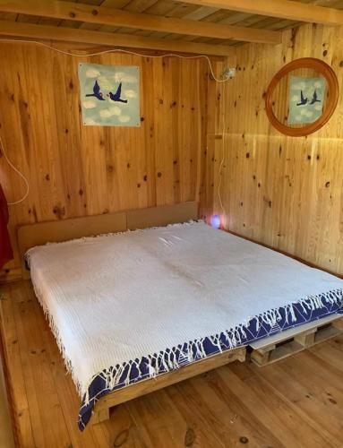 un lit dans une chambre avec un mur en bois dans l'établissement Studio chalet Sud Ouest, à Soustons