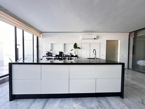 a kitchen with white cabinets and a black counter top at Playablanca Luxury Beach Apartment First Floor in Tanger in Tangier