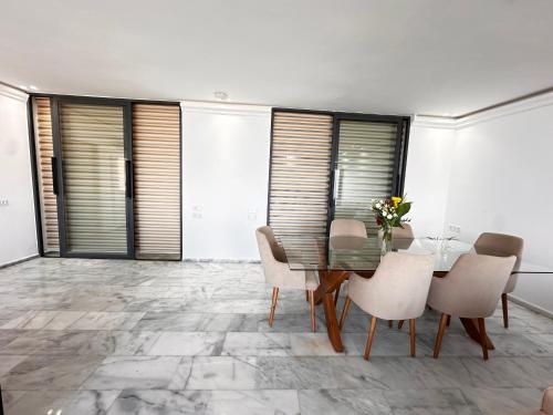 a dining room with a glass table and chairs at Playablanca Luxury Beach Apartment First Floor in Tanger in Tangier