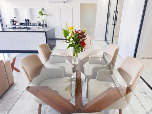 a dining room table with chairs and a vase of flowers at Playablanca Luxury Beach Apartment First Floor in Tanger in Tangier