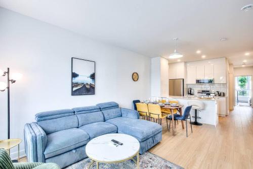 a living room with a blue couch and a kitchen at Beautiful & New! Renovated for your Style Comfort in Montréal
