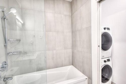 a bathroom with a shower and a washing machine at Beautiful & New! Renovated for your Style Comfort in Montréal