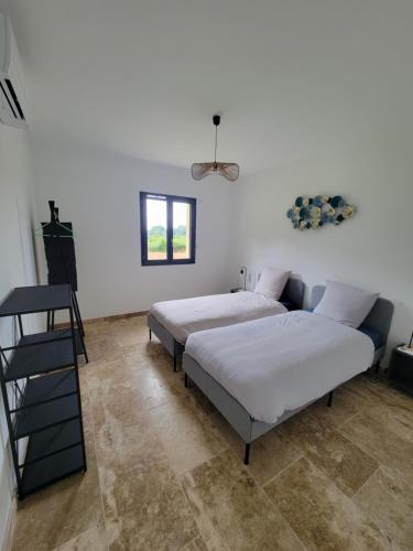 Ce lit se trouve dans un dortoir doté de murs blancs et de carrelage. dans l'établissement Belle maison neuve, au Buisson de Cadouin