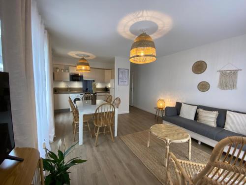 un salon avec un canapé et une table dans l'établissement Appartement Hakuna Matata 5 min Disney Parking, à Montévrain