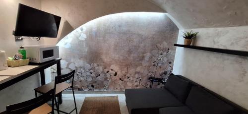 een kamer met een tafel en stoelen en een magnetron bij Lilly apartment in Catania