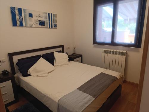a bedroom with a bed with white sheets and a window at Apartamento Montecanal 5 in Jaca